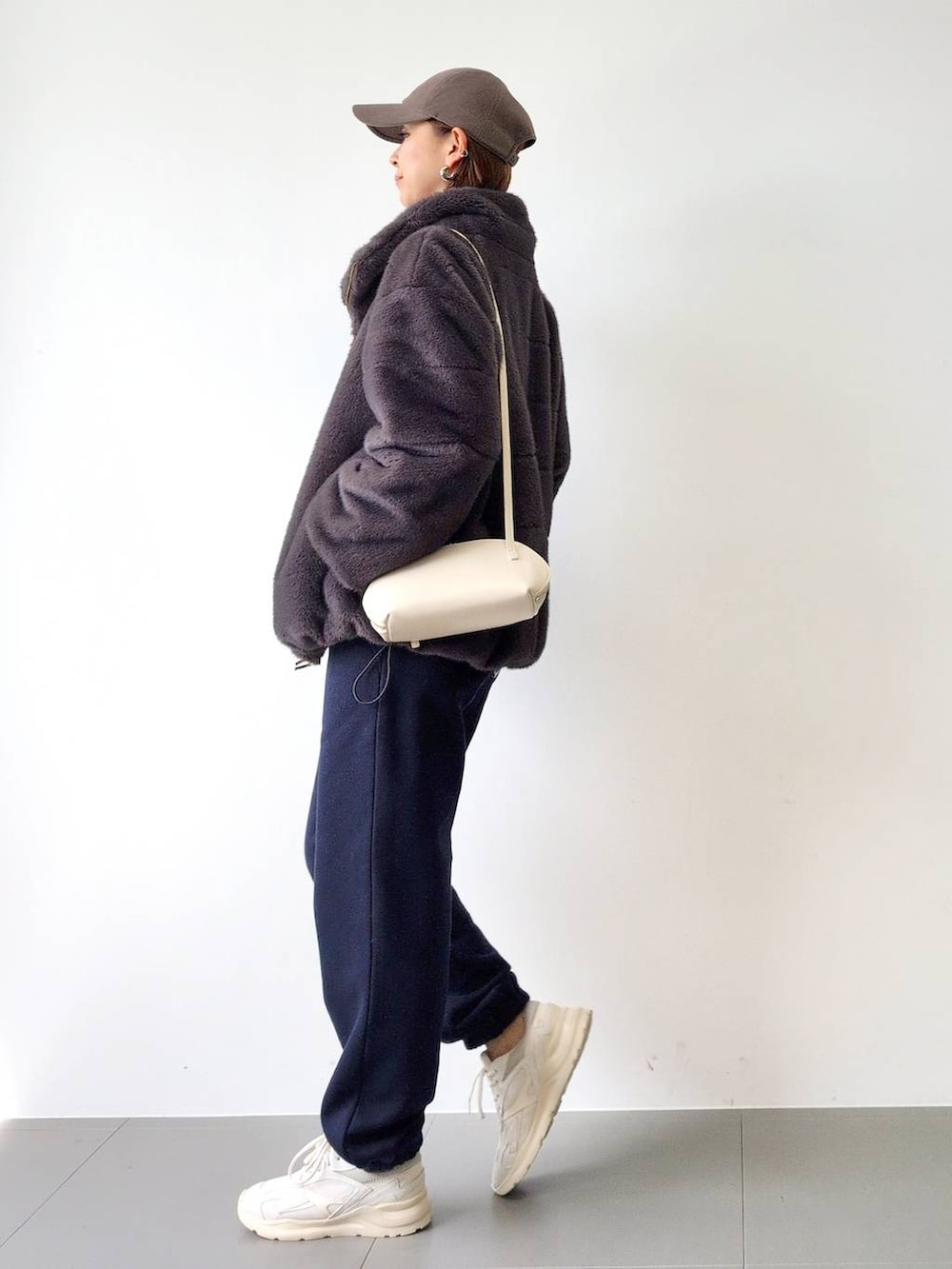 ホワイト系のショルダーバッグ、グレー系のブルゾン、ホワイト系のスニーカーを着用したレディースの秋コーディネートの6枚目の写真