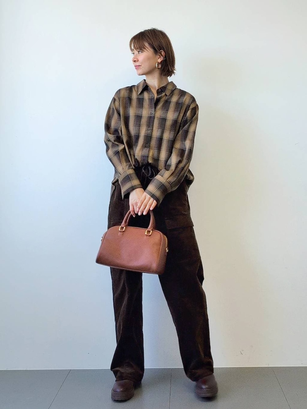 ブラウン系のブーツ、ブラウン系のボストンバッグ、ブラウン系のシャツ/ブラウスを着用したレディースの冬コーディネートの4枚目の写真