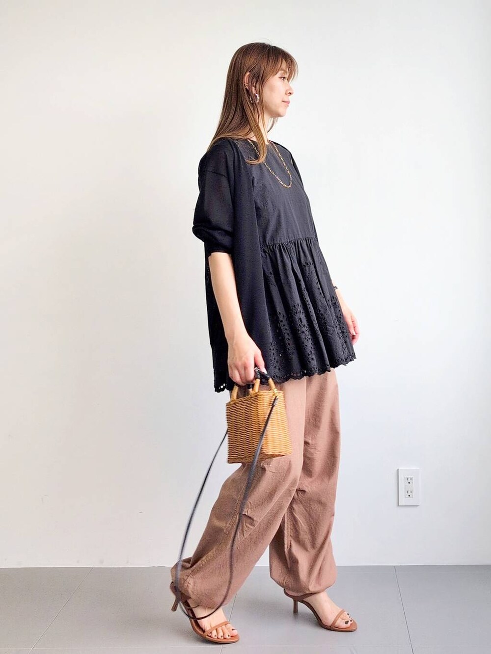 イエロー系のカーゴパンツ、ブラック系のショルダーバッグ、ブラウン系のサンダルを着用したレディースの夏コーディネートの4枚目の写真