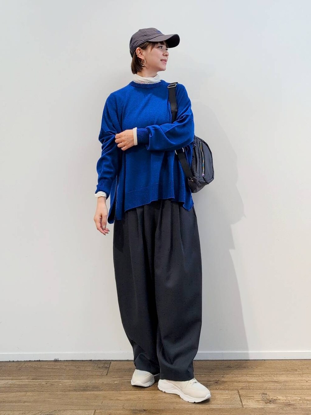 グレー系のボディバッグ/ウエストポーチ、ホワイト系のTシャツ/カットソー、グレー系のスラックスを着用したレディースの秋コーディネートの3枚目の写真