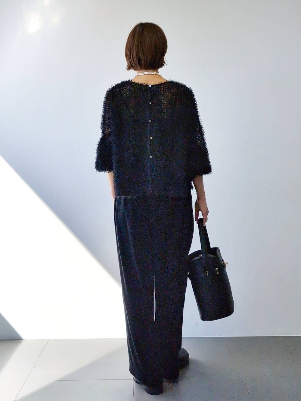 ブラック系のブーツ、ブラック系のハンドバッグ、ブラック系のキャミソールを着用したレディースの冬コーディネートの8枚目の写真