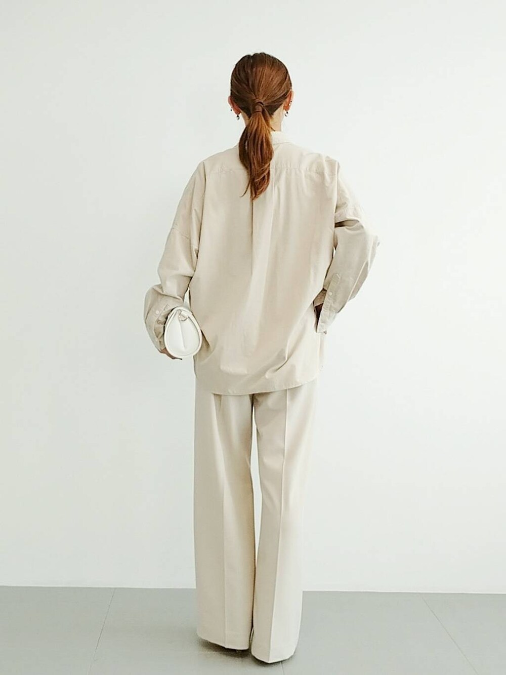 ベージュ系のスリッポン、ベージュ系のスラックス、その他のチョーカーを着用したレディースの夏コーディネートの4枚目の写真