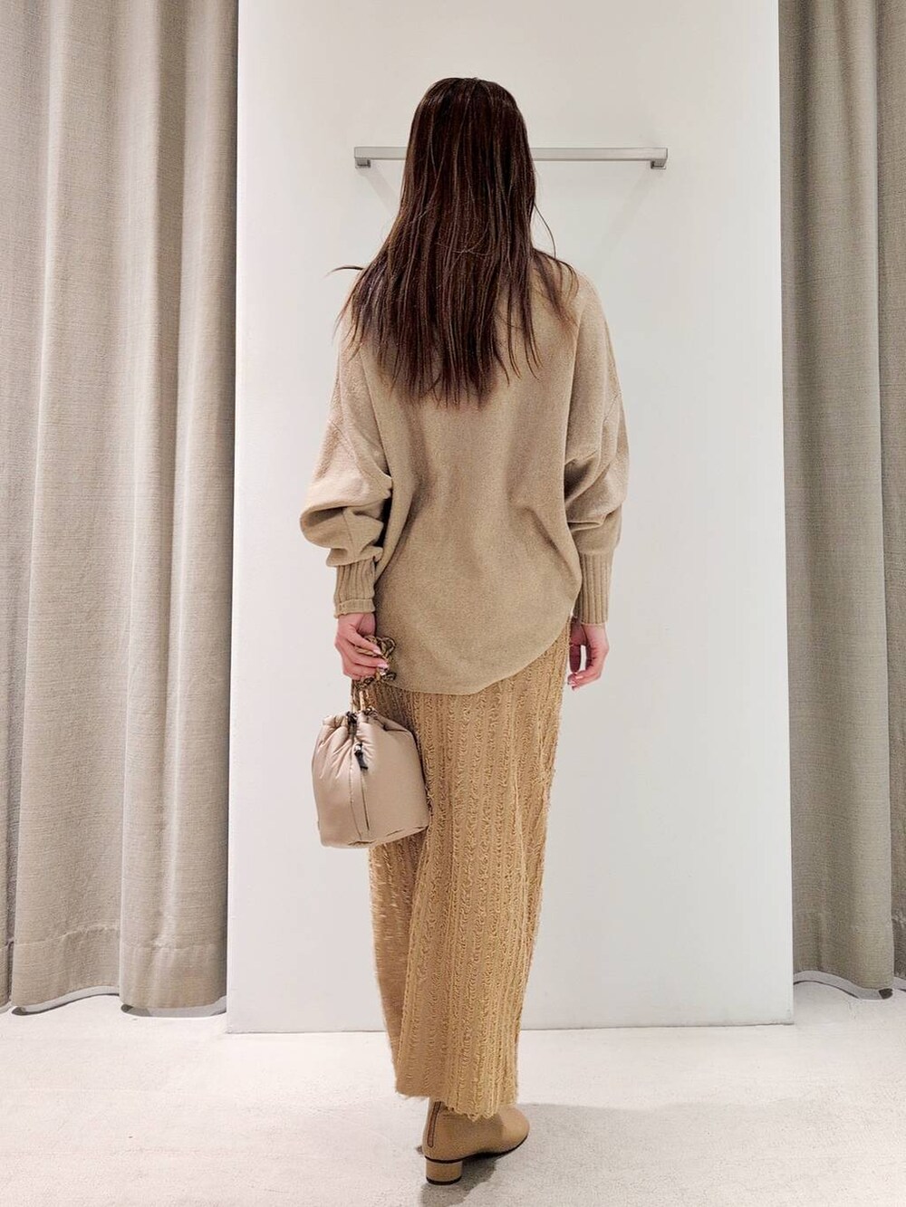 ベージュ系のブーツ、ベージュ系のショルダーバッグ、ベージュ系のニット/セーターを着用したレディースの冬コーディネートの6枚目の写真