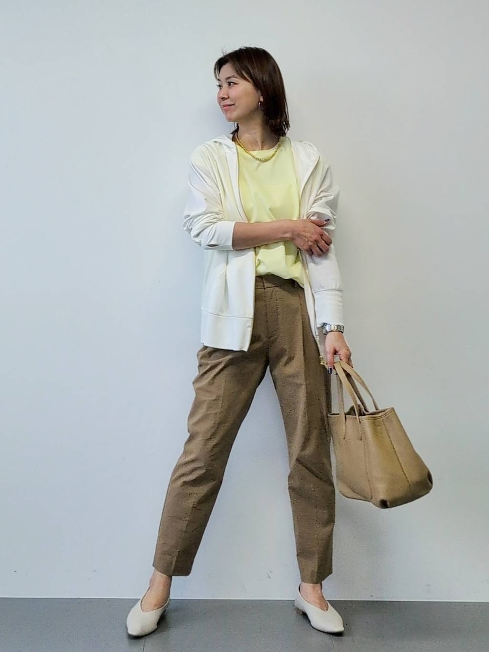 イエロー系のTシャツ/カットソー、ベージュ系のその他パンツ、ホワイト系のパーカーを着用したレディースの春コーディネートの5枚目の写真