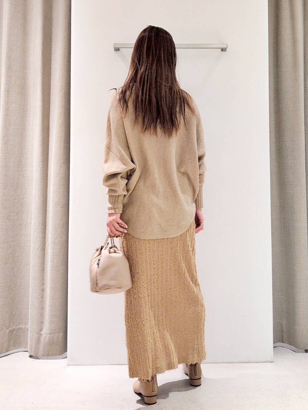 ベージュ系のブーツ、ベージュ系のショルダーバッグ、ベージュ系のニット/セーターを着用したレディースの冬コーディネートの5枚目の写真