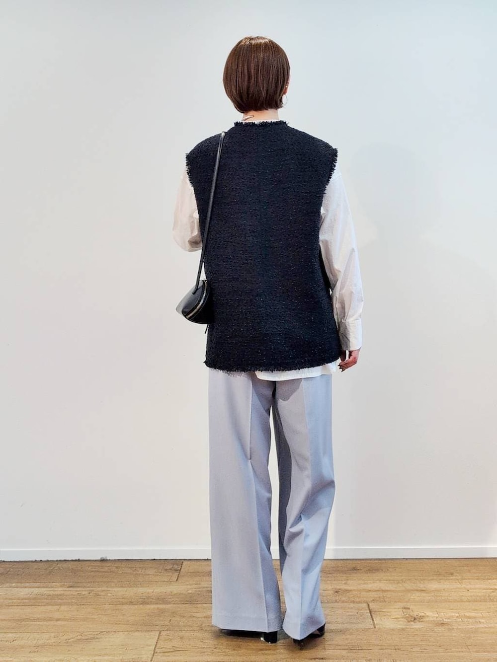 ブラック系のショルダーバッグ、ブラック系のブーツ、ホワイト系のシャツ/ブラウスを着用したレディースの冬コーディネートの9枚目の写真