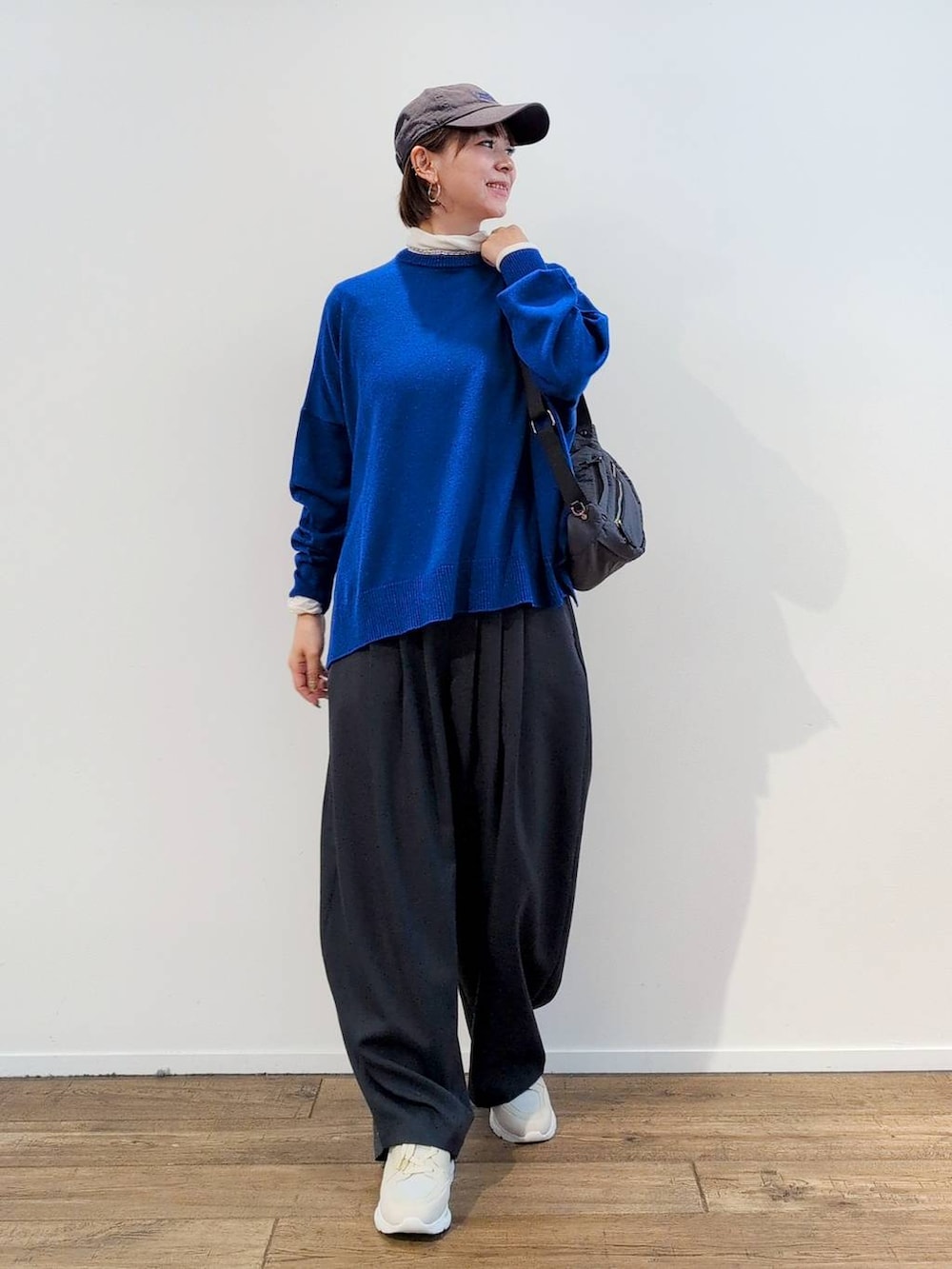 グレー系のボディバッグ/ウエストポーチ、ホワイト系のTシャツ/カットソー、グレー系のスラックスを着用したレディースの秋コーディネートの2枚目の写真