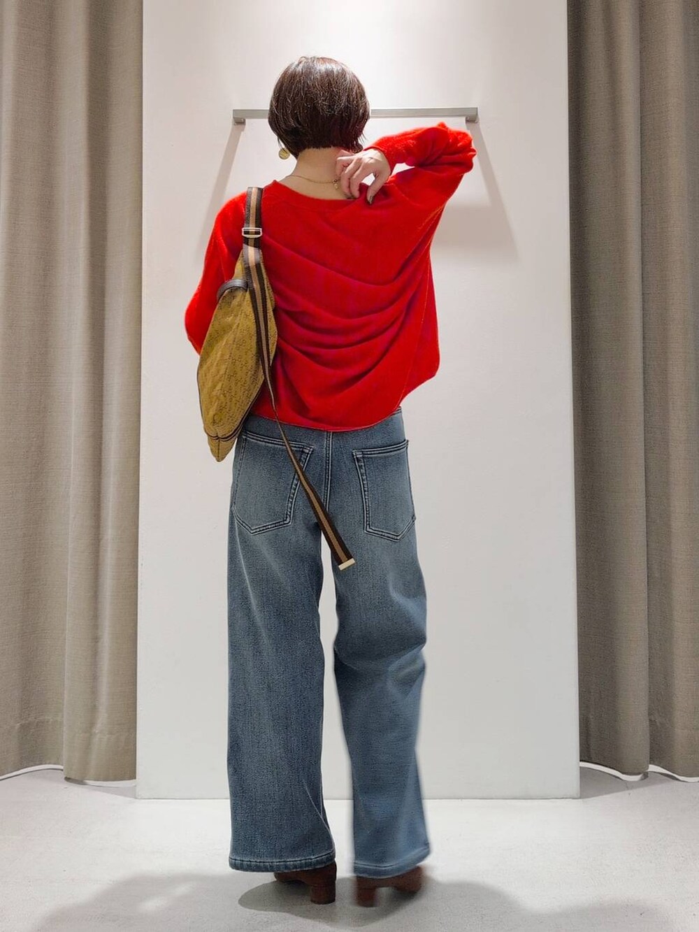 ブルー系のデニムパンツ、ブラウン系のパンプス、イエロー系のショルダーバッグを着用したレディースの秋コーディネートの9枚目の写真