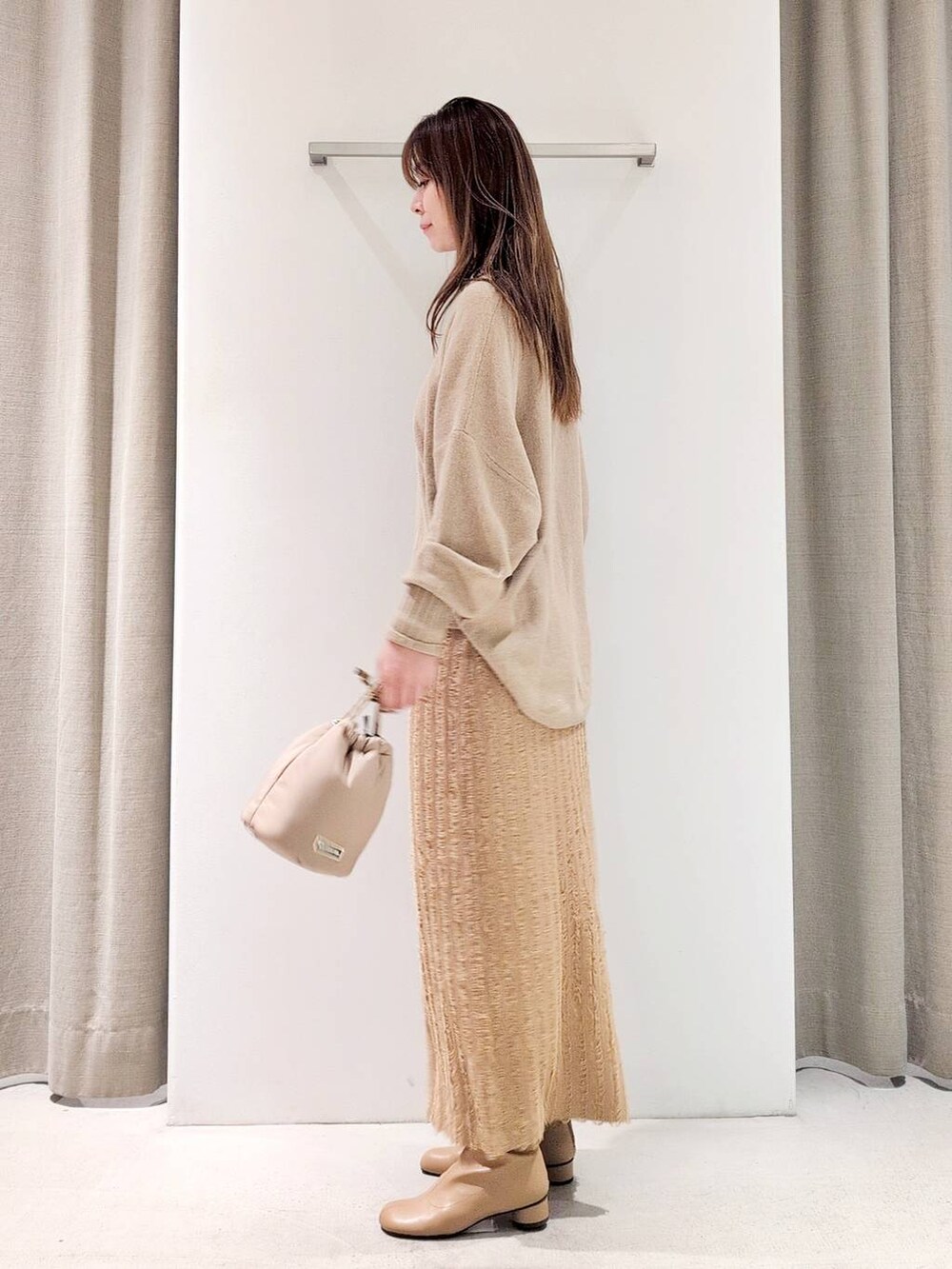 ベージュ系のブーツ、ベージュ系のショルダーバッグ、ベージュ系のニット/セーターを着用したレディースの冬コーディネートの3枚目の写真