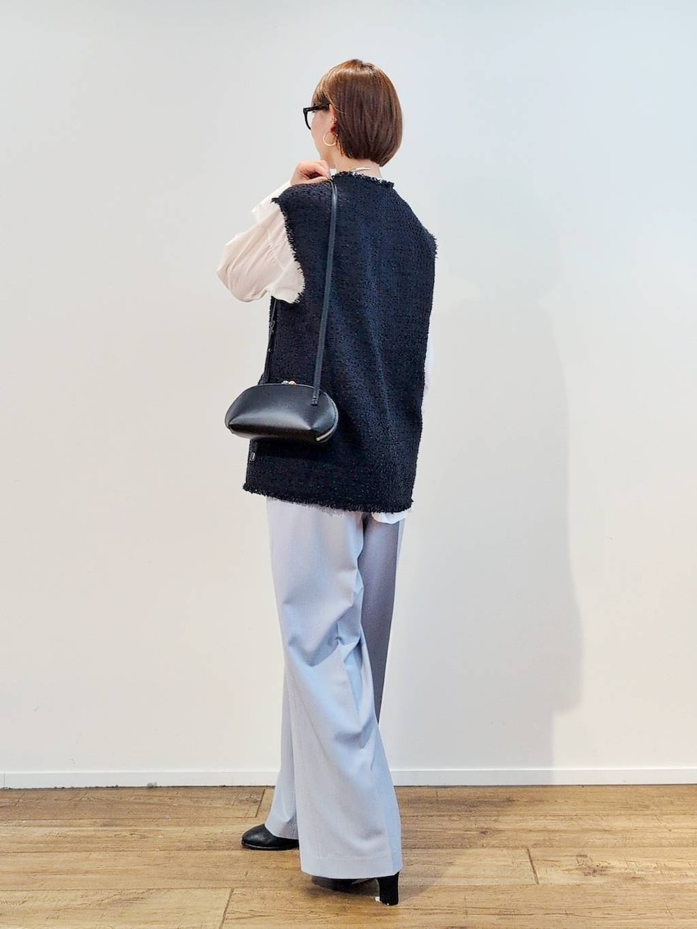 ブラック系のショルダーバッグ、ブラック系のブーツ、ホワイト系のシャツ/ブラウスを着用したレディースの冬コーディネートの7枚目の写真