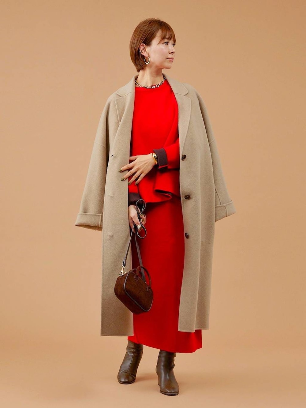 ベージュ系のチェスターコート、ブラウン系のショルダーバッグ、ブラウン系のブーツを着用したレディースの冬コーディネートの2枚目の写真