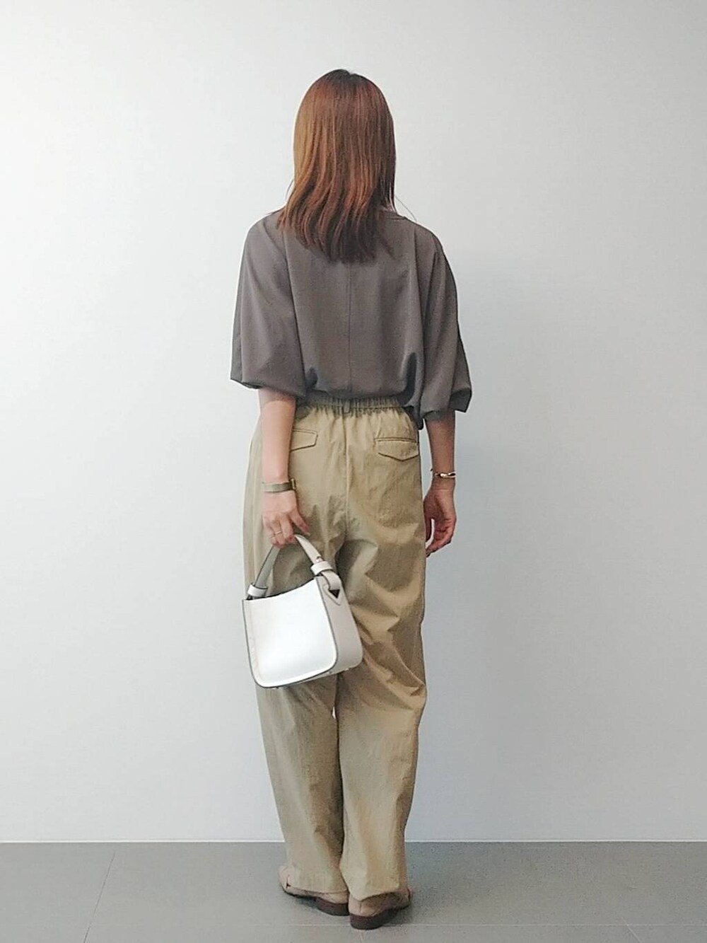 ホワイト系のハンドバッグ、ベージュ系のその他パンツ、ベージュ系のパンプスを着用したレディースの冬コーディネートの5枚目の写真