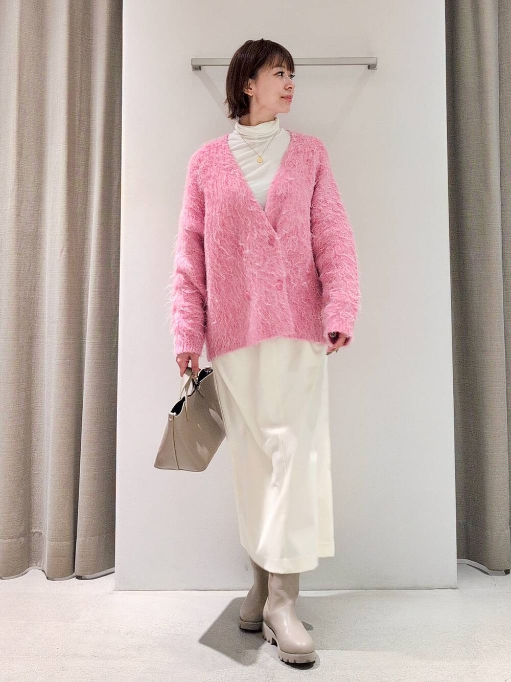 ホワイト系のTシャツ/カットソー、ベージュ系のピーコート、ホワイト系のスカートを着用したレディースの秋コーディネートの5枚目の写真