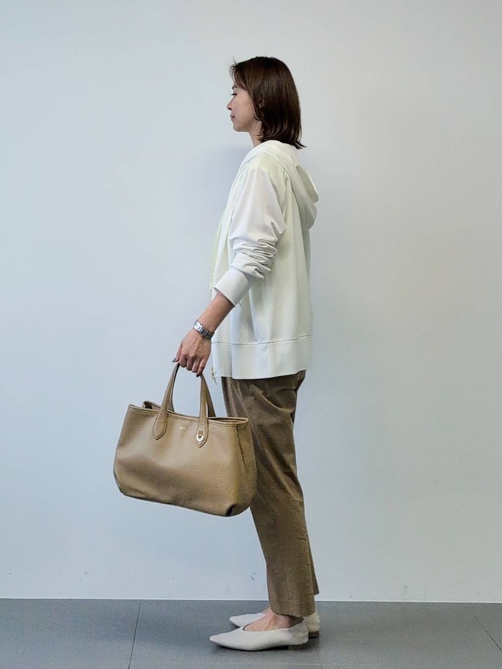 イエロー系のTシャツ/カットソー、ベージュ系のその他パンツ、ホワイト系のパーカーを着用したレディースの春コーディネートの6枚目の写真