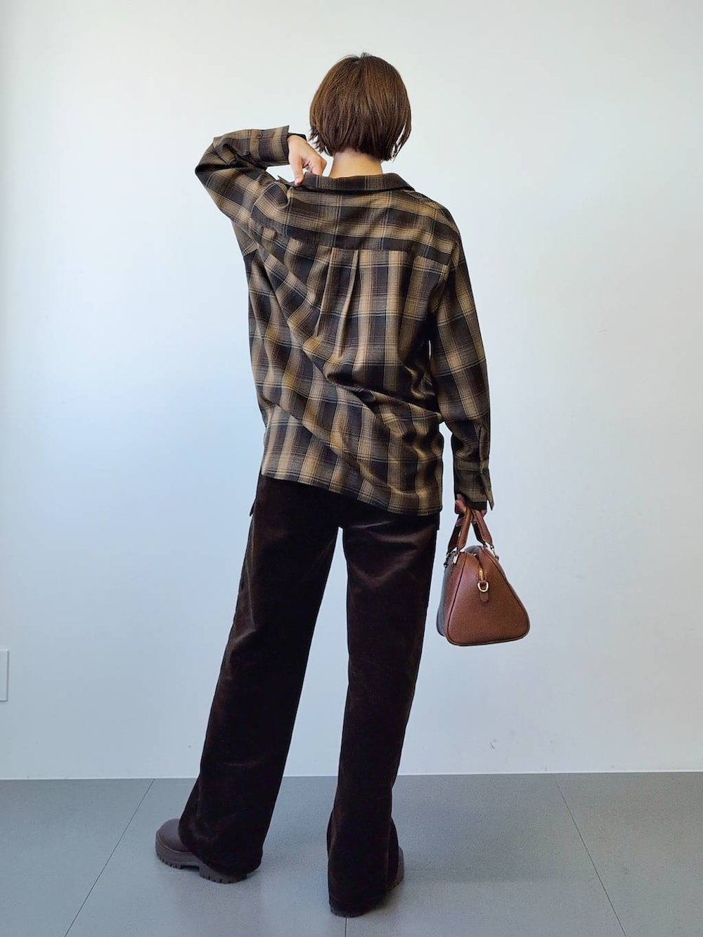 ブラウン系のブーツ、ブラウン系のボストンバッグ、ブラウン系のシャツ/ブラウスを着用したレディースの冬コーディネートの8枚目の写真