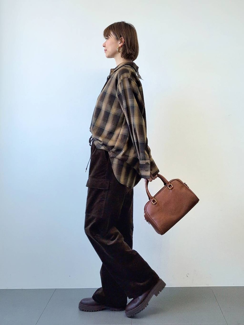 ブラウン系のブーツ、ブラウン系のボストンバッグ、ブラウン系のシャツ/ブラウスを着用したレディースの冬コーディネートの6枚目の写真