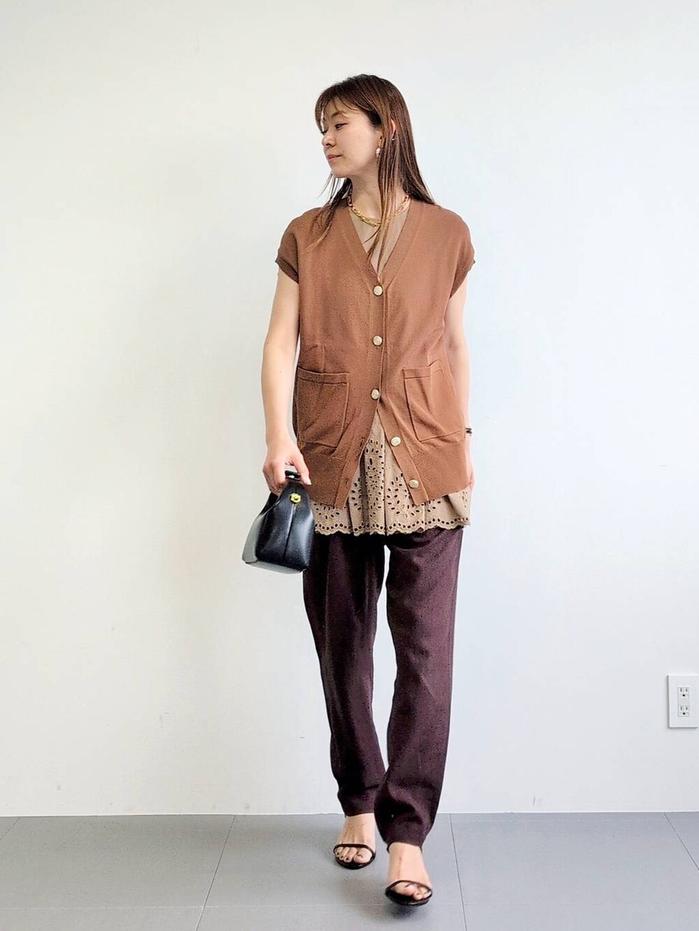 ブラック系のサンダル、ブラウン系のその他パンツ、イエロー系のニット/セーターを着用したレディースの夏コーディネートの2枚目の写真