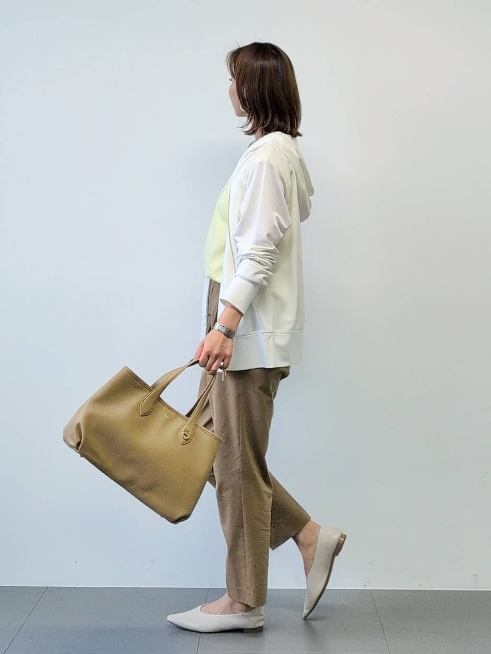 イエロー系のTシャツ/カットソー、ベージュ系のその他パンツ、ホワイト系のパーカーを着用したレディースの春コーディネートの8枚目の写真
