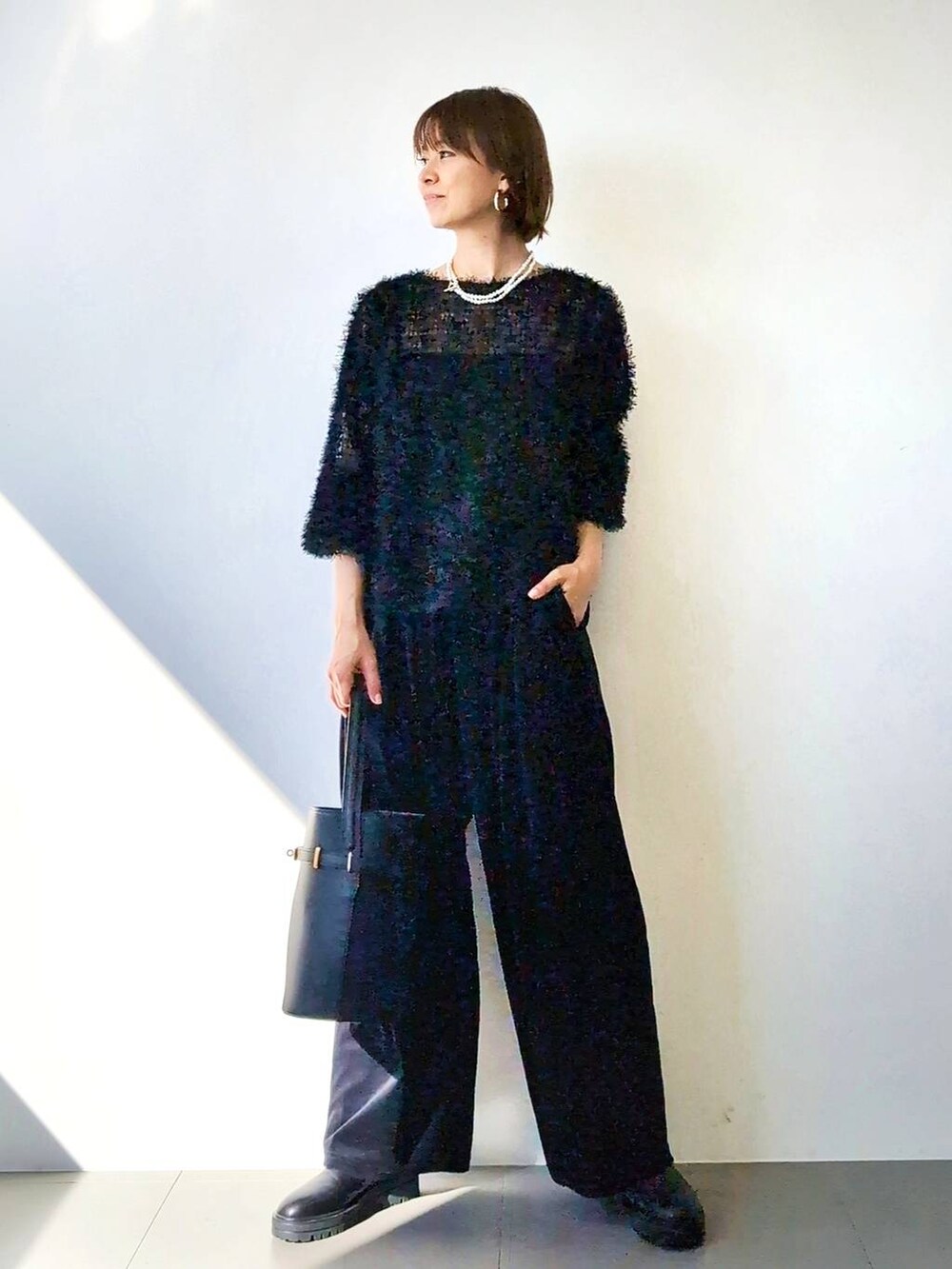 ブラック系のブーツ、ブラック系のハンドバッグ、ブラック系のキャミソールを着用したレディースの冬コーディネートの2枚目の写真