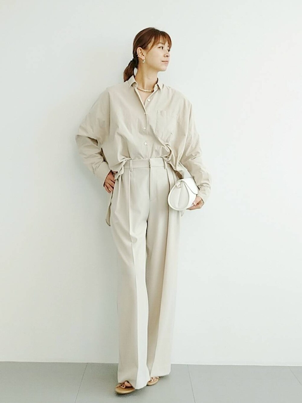 ベージュ系のスリッポン、ベージュ系のスラックス、その他のチョーカーを着用したレディースの夏コーディネートの2枚目の写真