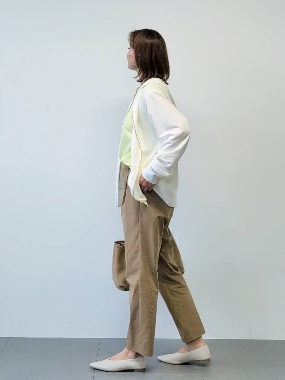 イエロー系のTシャツ/カットソー、ベージュ系のその他パンツ、ホワイト系のパーカーを着用したレディースの春コーディネートの7枚目の写真