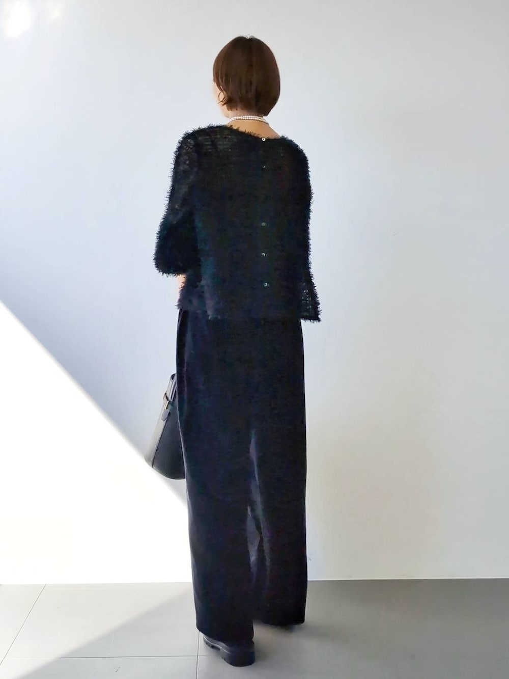 ブラック系のブーツ、ブラック系のハンドバッグ、ブラック系のキャミソールを着用したレディースの冬コーディネートの7枚目の写真