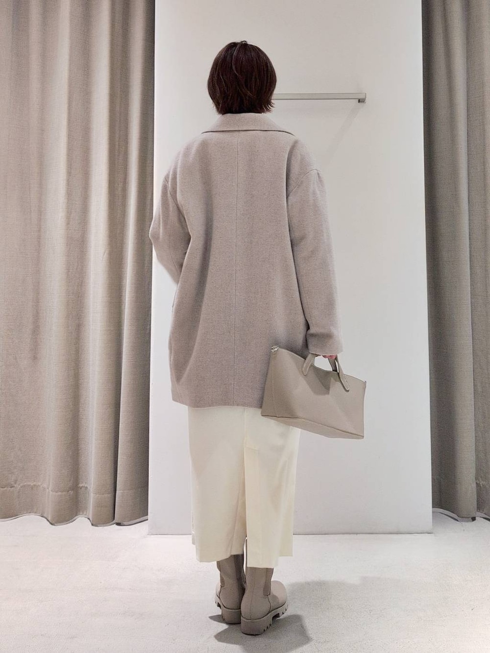 ホワイト系のTシャツ/カットソー、ベージュ系のピーコート、ホワイト系のスカートを着用したレディースの秋コーディネートの4枚目の写真