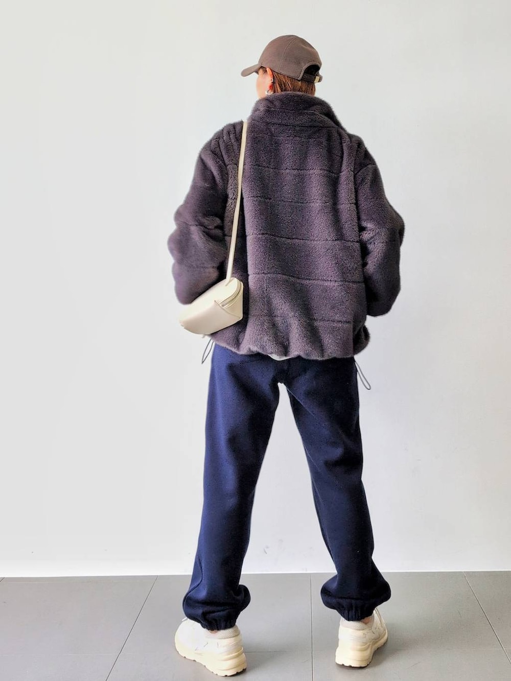 ホワイト系のショルダーバッグ、グレー系のブルゾン、ホワイト系のスニーカーを着用したレディースの秋コーディネートの7枚目の写真