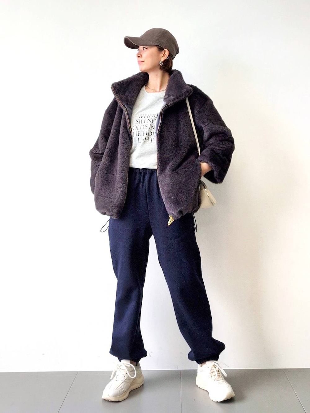 ホワイト系のショルダーバッグ、グレー系のブルゾン、ホワイト系のスニーカーを着用したレディースの秋コーディネートの3枚目の写真