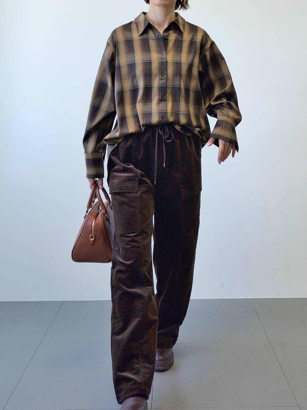 ブラウン系のブーツ、ブラウン系のボストンバッグ、ブラウン系のシャツ/ブラウスを着用したレディースの冬コーディネートの9枚目の写真