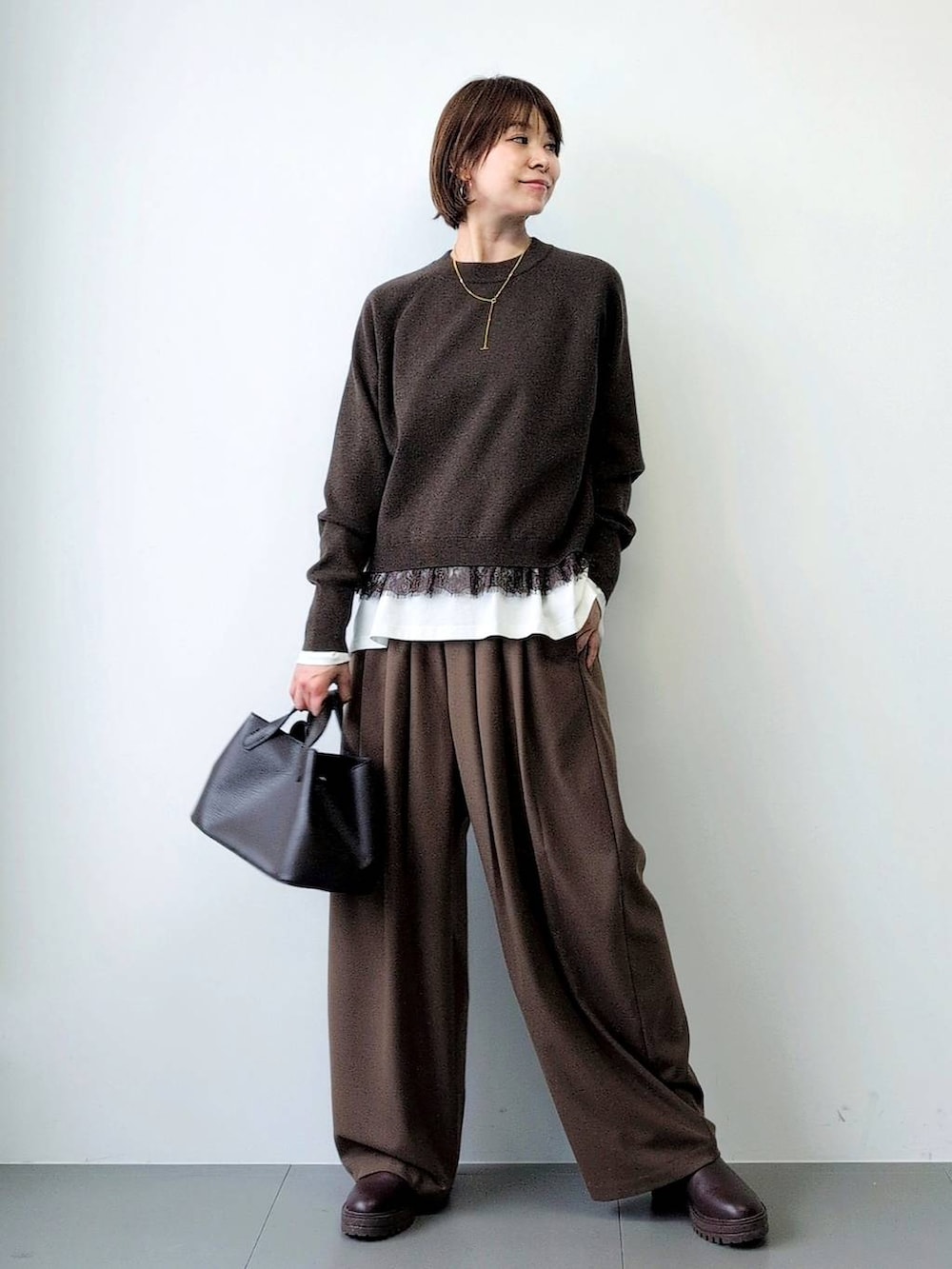 ブラウン系のブーツ、ブラウン系のショルダーバッグ、ブラウン系のその他パンツを着用したレディースの秋コーディネートの2枚目の写真