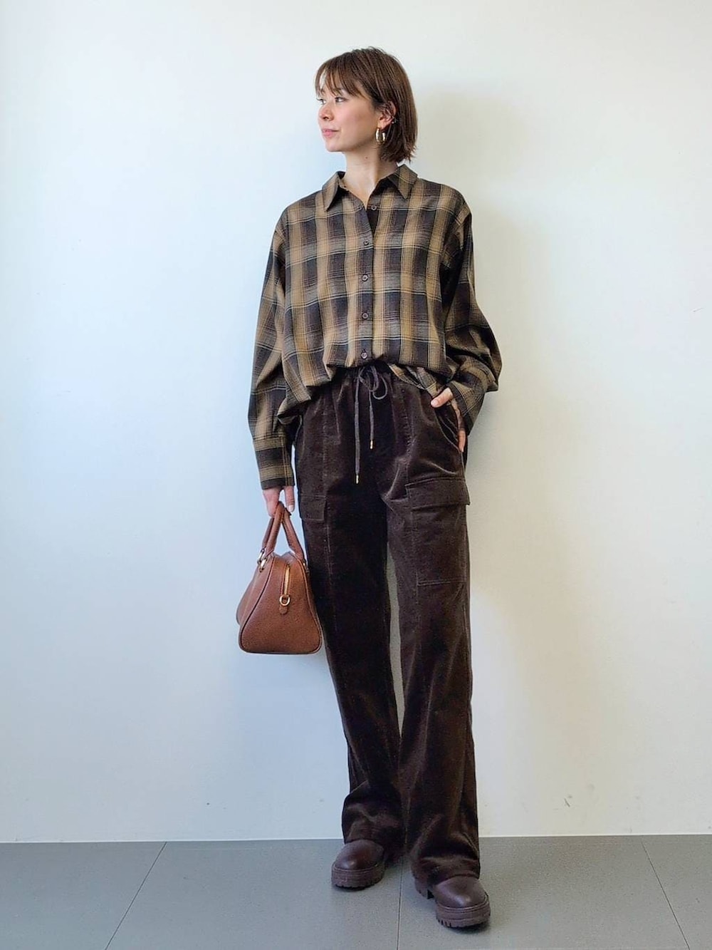 ブラウン系のブーツ、ブラウン系のボストンバッグ、ブラウン系のシャツ/ブラウスを着用したレディースの冬コーディネートの5枚目の写真