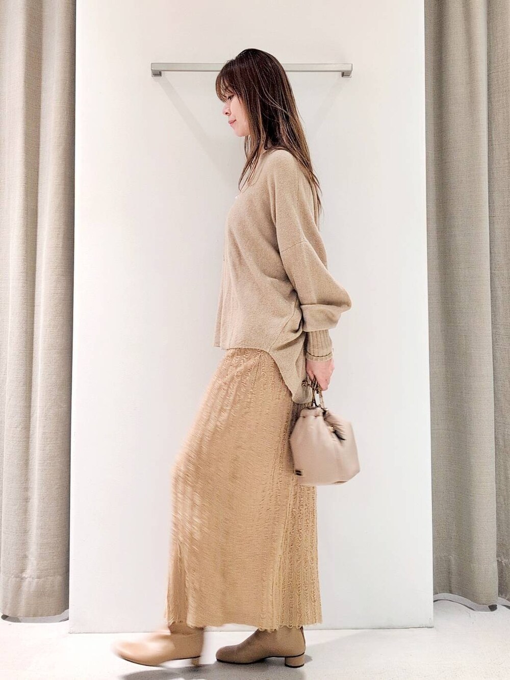 ベージュ系のブーツ、ベージュ系のショルダーバッグ、ベージュ系のニット/セーターを着用したレディースの冬コーディネートの4枚目の写真