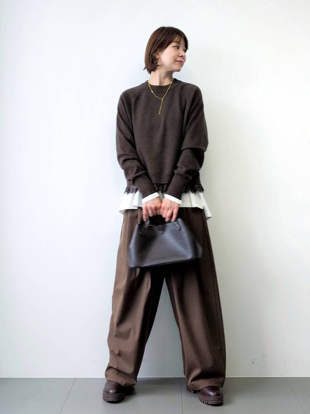 ブラウン系のブーツ、ブラウン系のショルダーバッグ、ブラウン系のその他パンツを着用したレディースの秋コーディネートの3枚目の写真