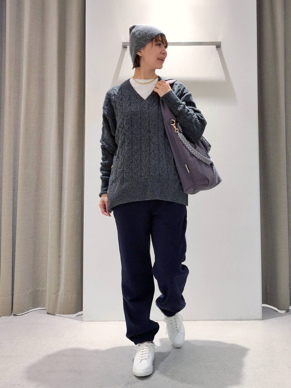 ホワイト系のTシャツ/カットソー、グレー系のショルダーバッグ、グレー系のニット/セーターを着用したレディースの秋コーディネートの2枚目の写真