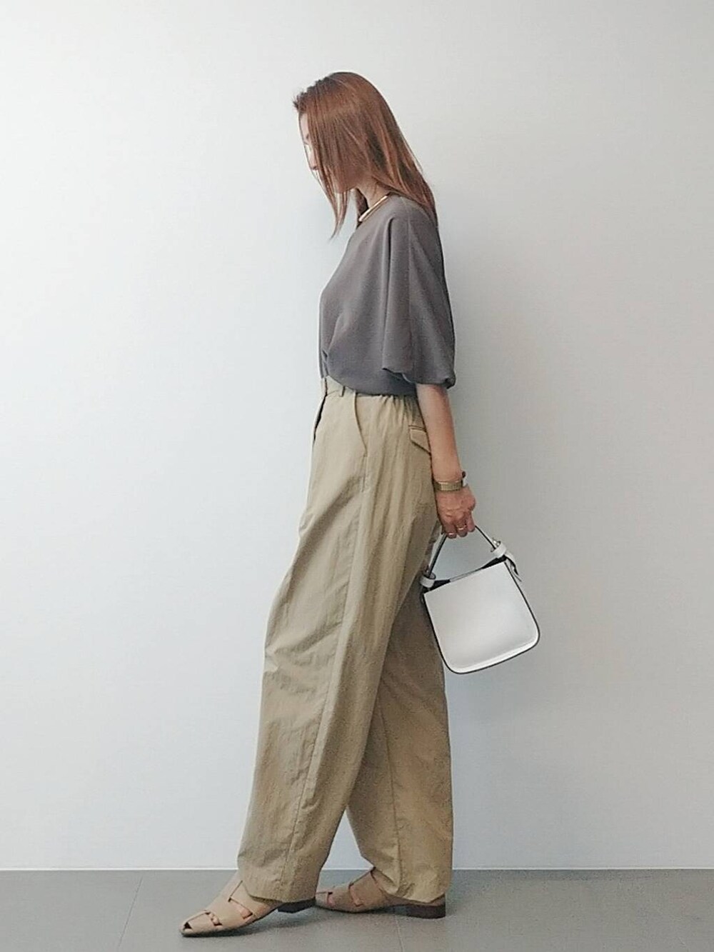 ホワイト系のハンドバッグ、ベージュ系のその他パンツ、ベージュ系のパンプスを着用したレディースの冬コーディネートの3枚目の写真