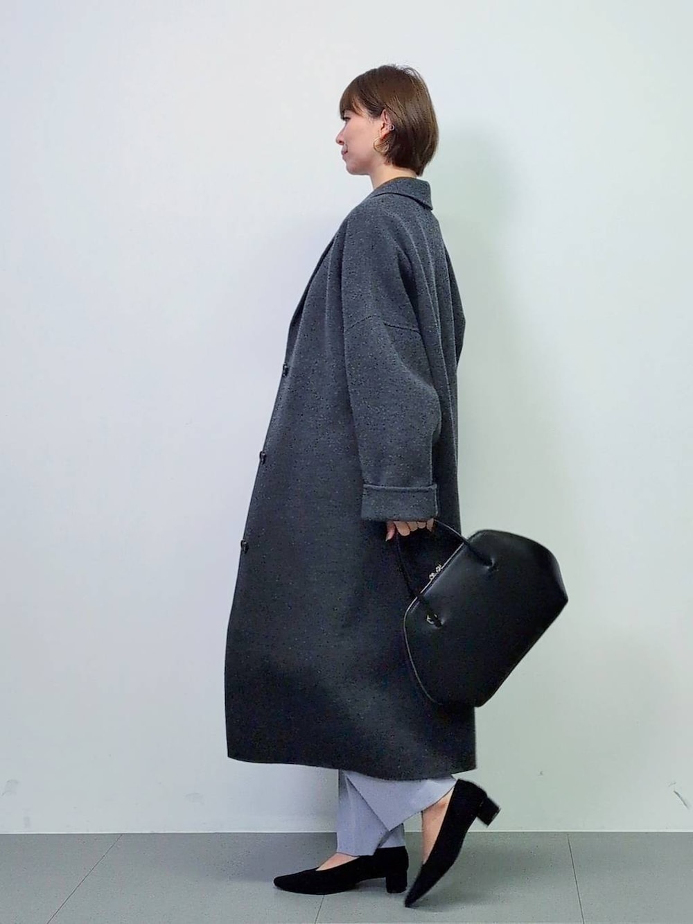 ブラック系のトートバッグ、グレー系のチェスターコート、ブラック系のパンプスを着用したレディースの秋コーディネートの7枚目の写真