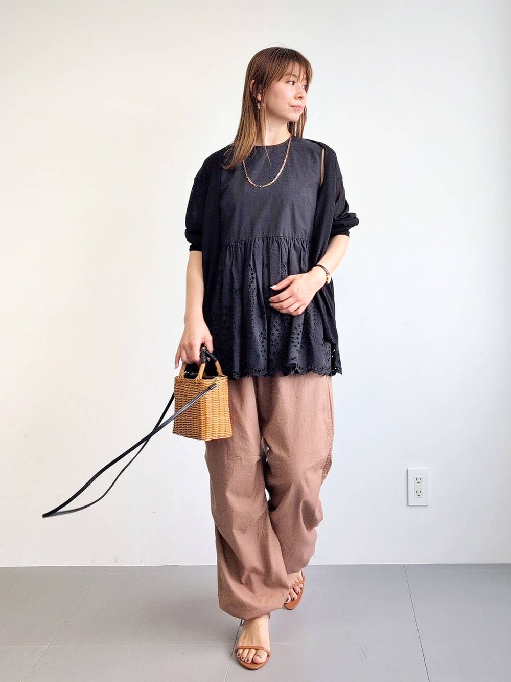 イエロー系のカーゴパンツ、ブラック系のショルダーバッグ、ブラウン系のサンダルを着用したレディースの夏コーディネートの3枚目の写真