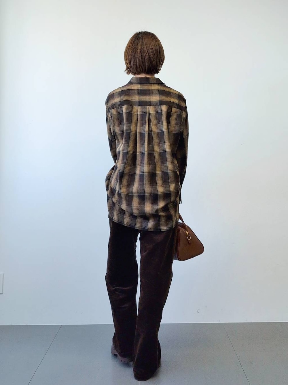 ブラウン系のブーツ、ブラウン系のボストンバッグ、ブラウン系のシャツ/ブラウスを着用したレディースの冬コーディネートの7枚目の写真