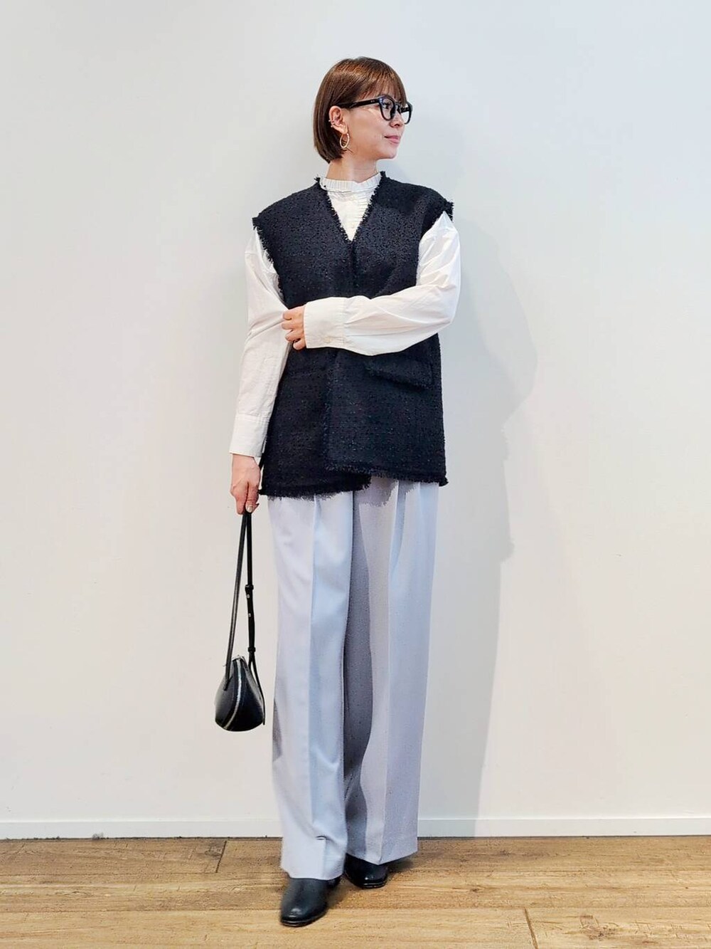 ブラック系のショルダーバッグ、ブラック系のブーツ、ホワイト系のシャツ/ブラウスを着用したレディースの冬コーディネートの5枚目の写真