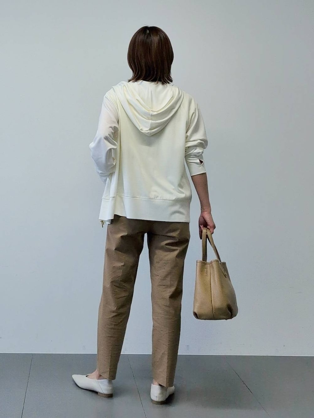 イエロー系のTシャツ/カットソー、ベージュ系のその他パンツ、ホワイト系のパーカーを着用したレディースの春コーディネートの9枚目の写真