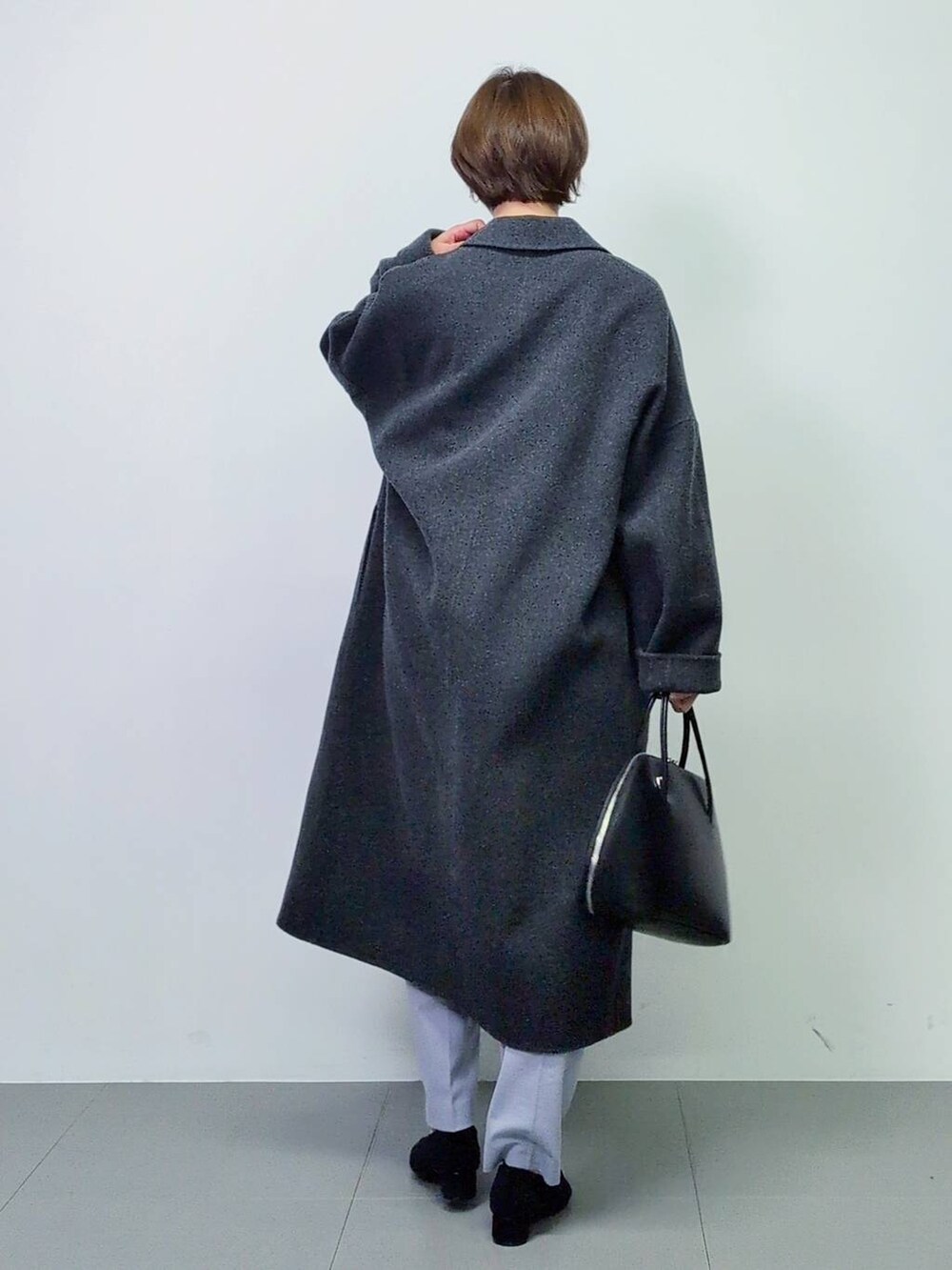 ブラック系のトートバッグ、グレー系のチェスターコート、ブラック系のパンプスを着用したレディースの秋コーディネートの9枚目の写真