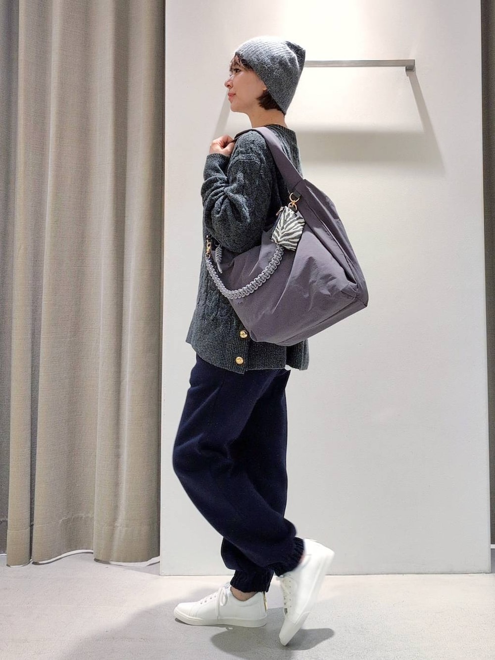 ホワイト系のTシャツ/カットソー、グレー系のショルダーバッグ、グレー系のニット/セーターを着用したレディースの秋コーディネートの7枚目の写真