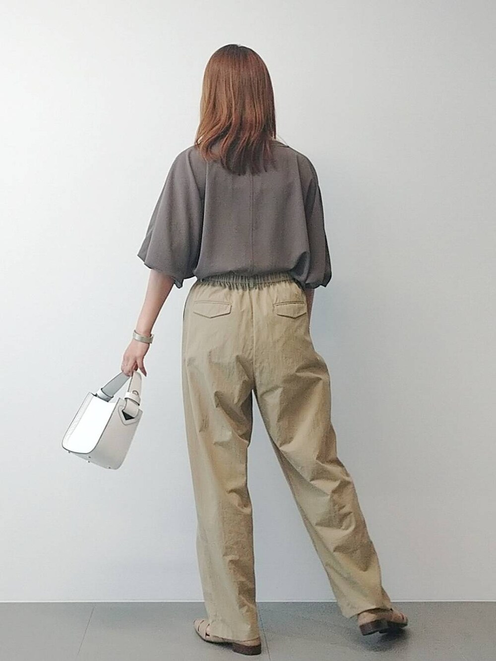 ホワイト系のハンドバッグ、ベージュ系のその他パンツ、ベージュ系のパンプスを着用したレディースの冬コーディネートの4枚目の写真