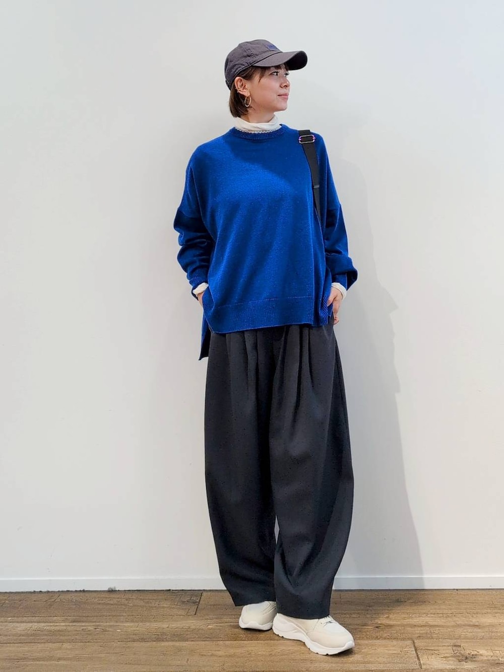 グレー系のボディバッグ/ウエストポーチ、ホワイト系のTシャツ/カットソー、グレー系のスラックスを着用したレディースの秋コーディネートの4枚目の写真