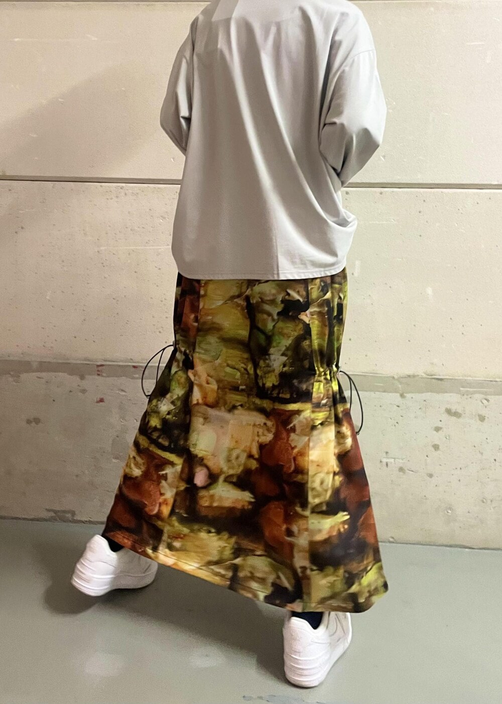 ホワイト系のスニーカー、イエロー系のワンピース、グレー系のTシャツ/カットソーを着用したレディースの冬コーディネートの4枚目の写真