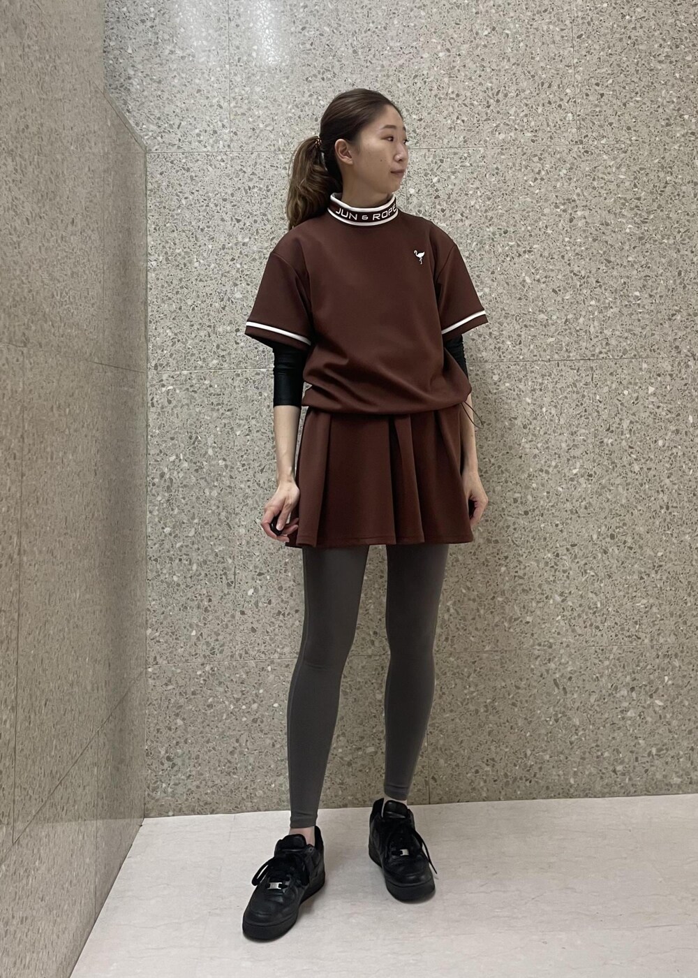 ブラウン系のスカート、ブラウン系のTシャツ/カットソーを着用したレディースの秋コーディネートの2枚目の写真