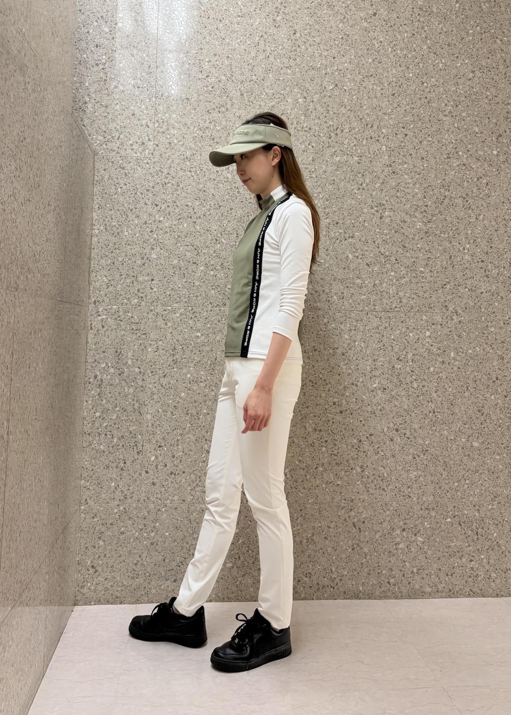 グリーン系のTシャツ/カットソー、ホワイト系のその他パンツ、グリーン系のサンバイザーを着用したレディースの秋コーディネートの5枚目の写真