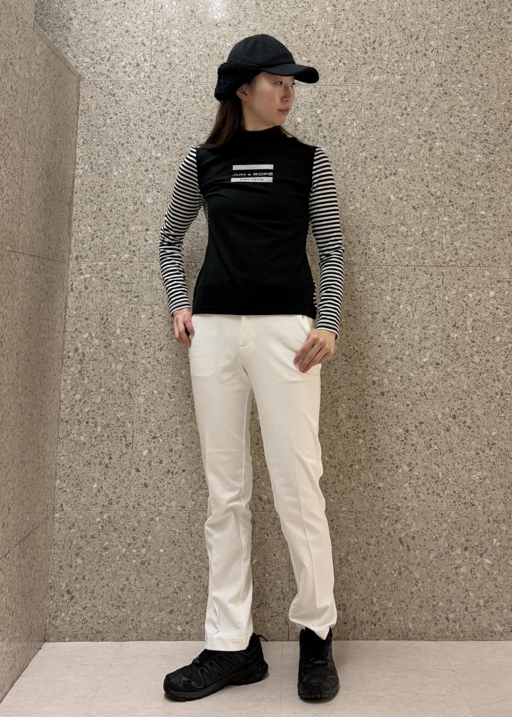 ホワイト系のその他パンツ、ブラック系のTシャツ/カットソー、ブラック系のキャップを着用したレディースの冬コーディネートの2枚目の写真