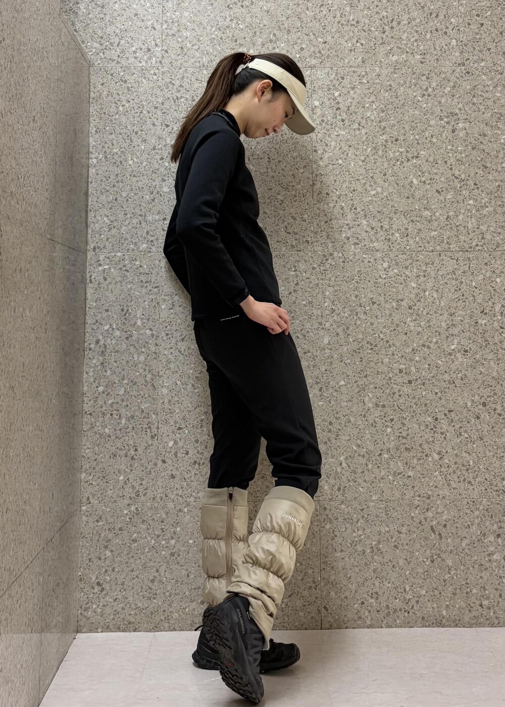 ブラック系のその他パンツ、ブラック系のTシャツ/カットソー、ベージュ系のサンバイザーを着用したレディースの冬コーディネートの4枚目の写真